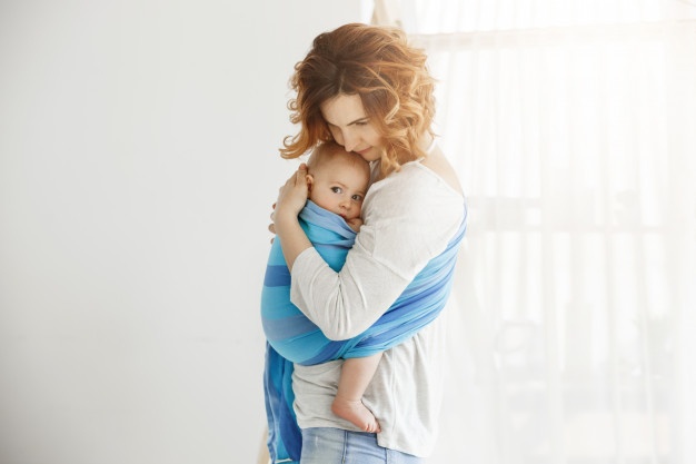 young-good-looking-mother-snuggles-calming-her-newborn-son-who-feeling-scared-after-long-sleep-interrupted-by-loud-sounds-from-street-scene-protection-love_176420-12230